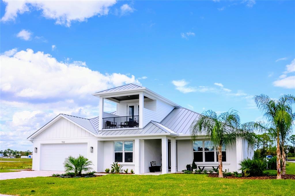 a front view of a house with a garden and trees