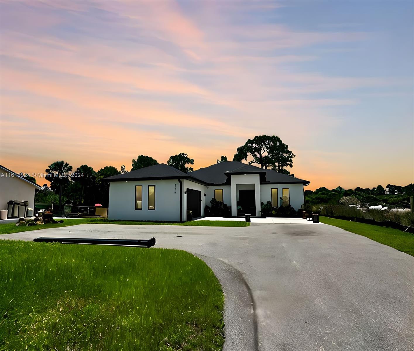 a front view of a house with a yard and trees