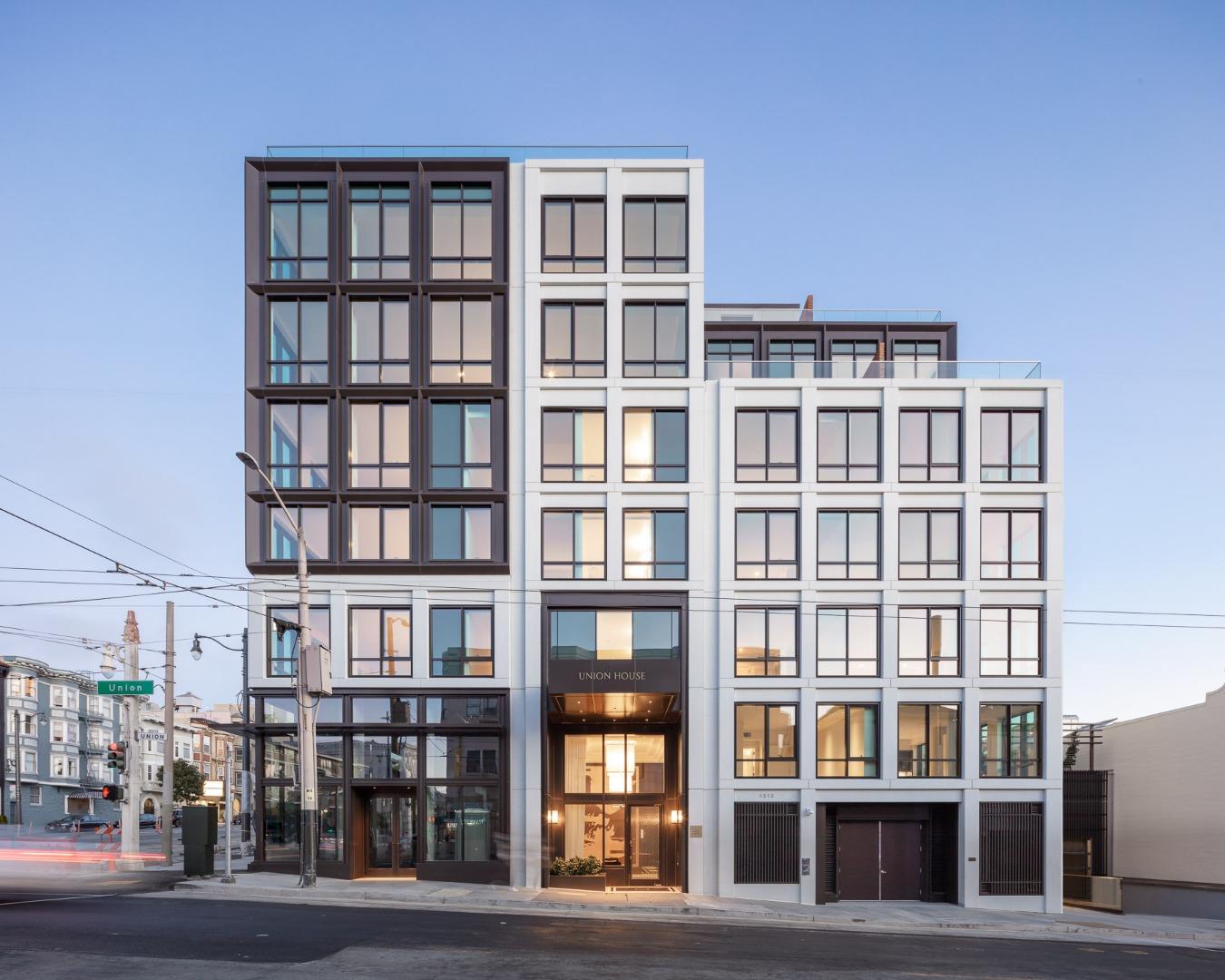 a front view of a residential apartment building with a yard