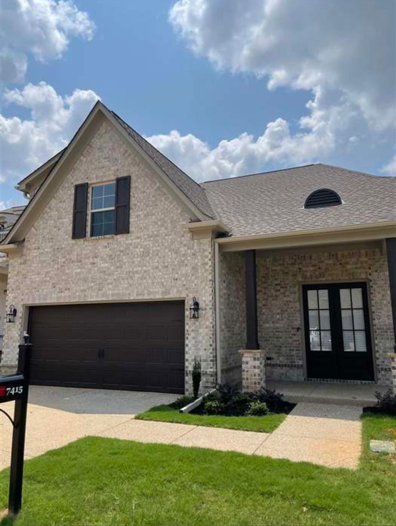 View of front facade featuring a front yard and a garage