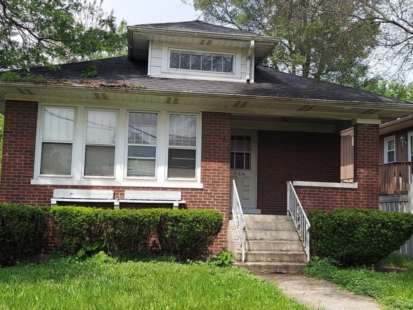 a front view of a house with a garden