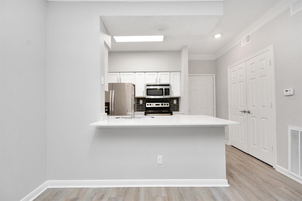 a view of a kitchen with electric appliances