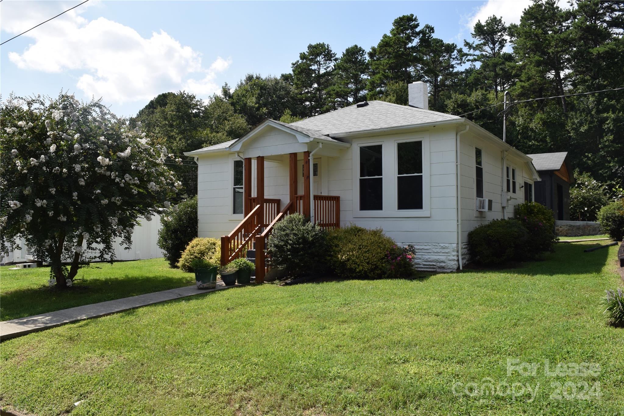 a front view of a house with a yard and trees