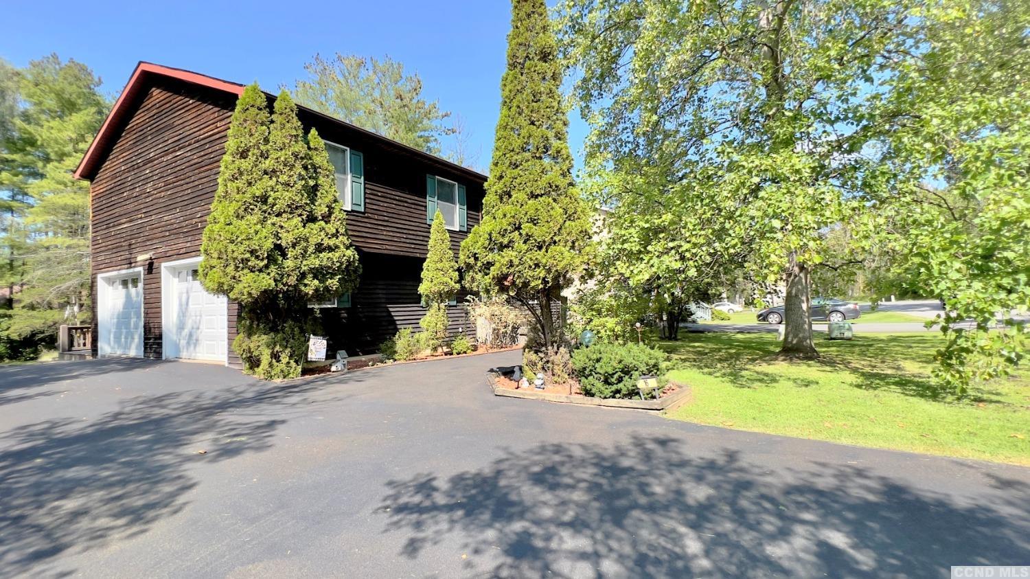 a view of a house with backyard and trees