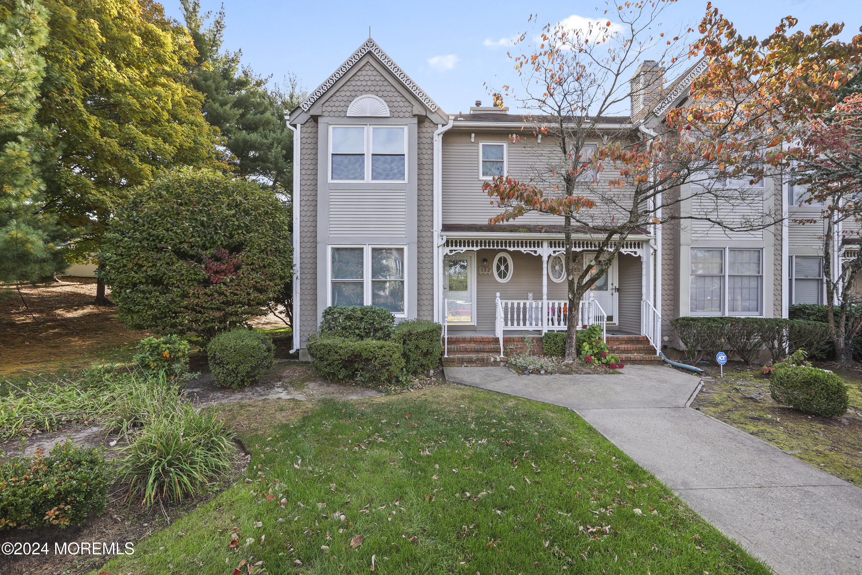 a front view of a house with yard and green space