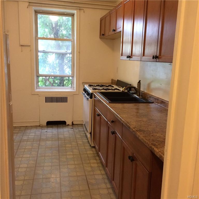 a kitchen with granite countertop stainless steel appliances a stove and a window