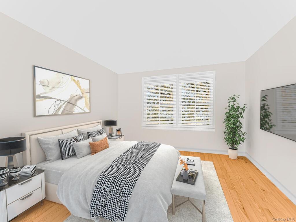 Bedroom featuring light hardwood / wood-style flooring and vaulted ceiling - virtually staged