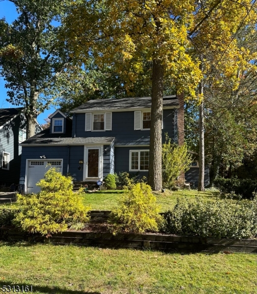 a front view of a house with a yard with potted plants