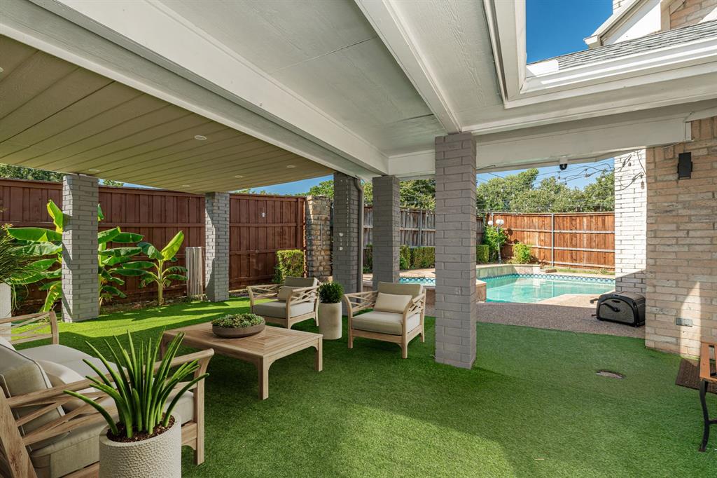 a living room with patio furniture and a garden