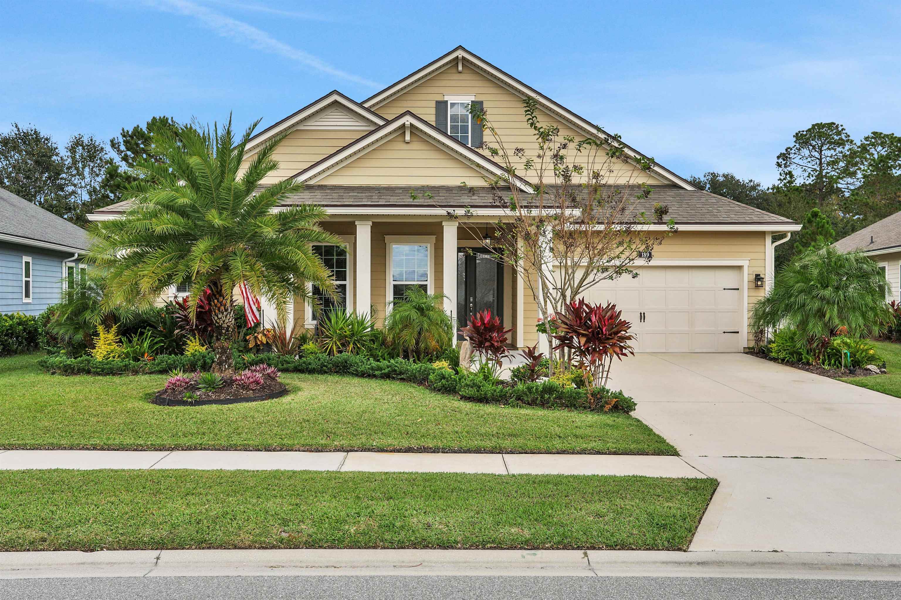 a front view of a house with a yard and potted plants