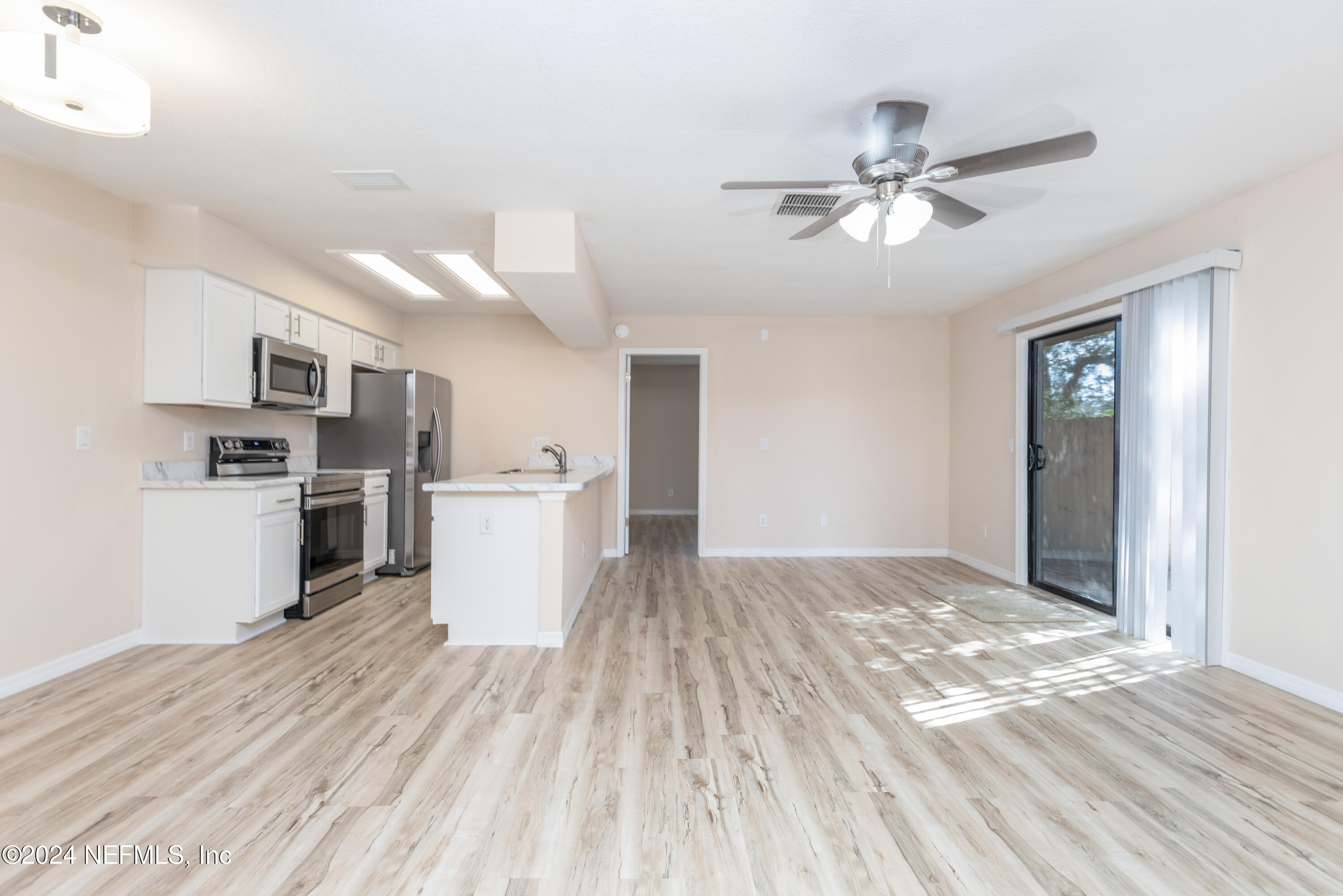 a view of a kitchen with wooden floor and a kitchen