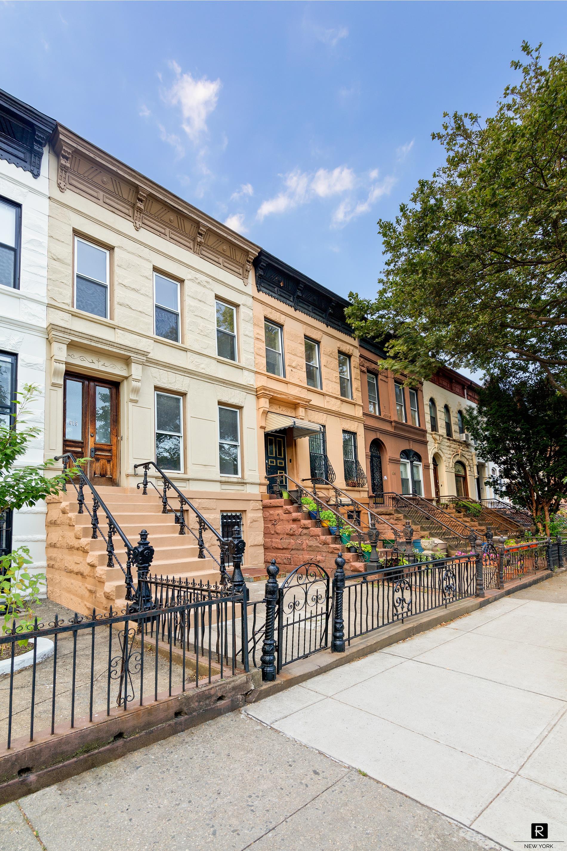 a front view of a brick house with a wooden fence