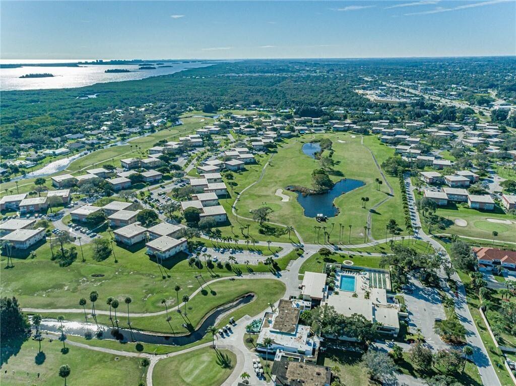 an aerial view of residential houses with outdoor space and trees