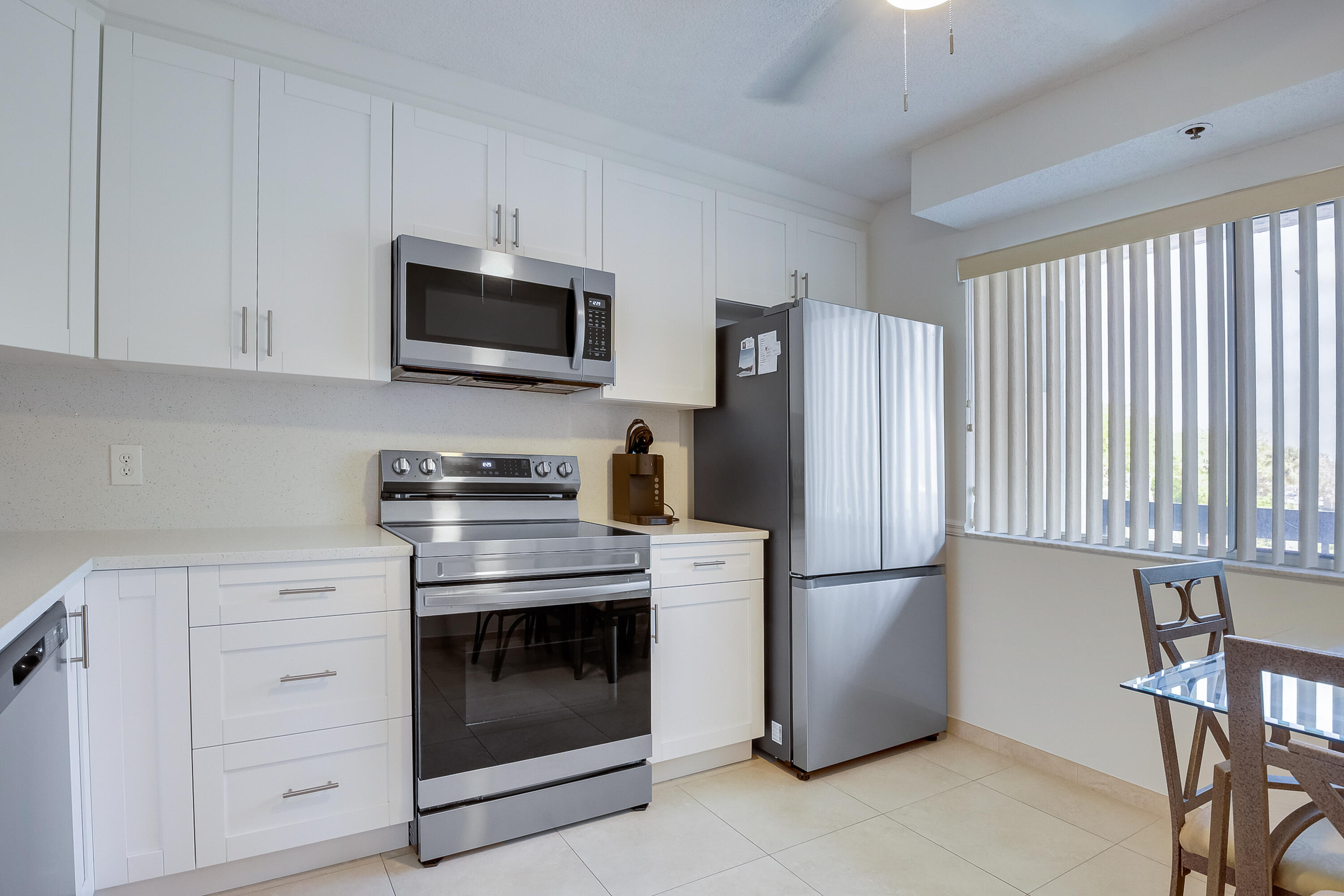 a kitchen with stainless steel appliances white cabinets and a stove top oven