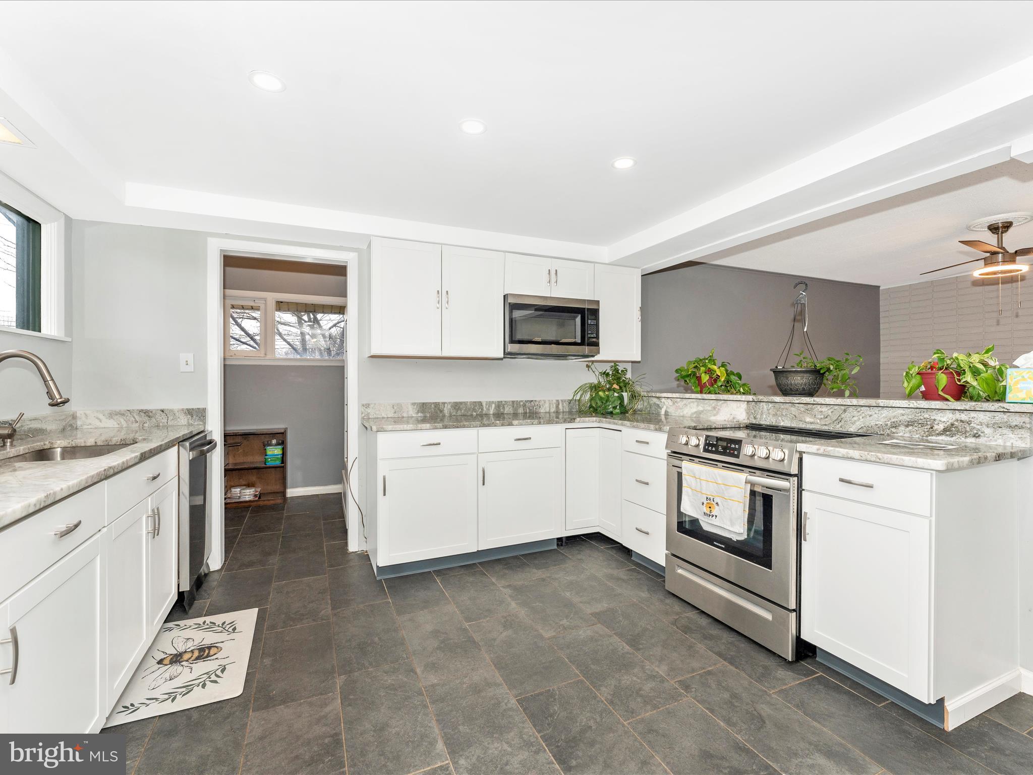 a kitchen with granite countertop white cabinets and white appliances