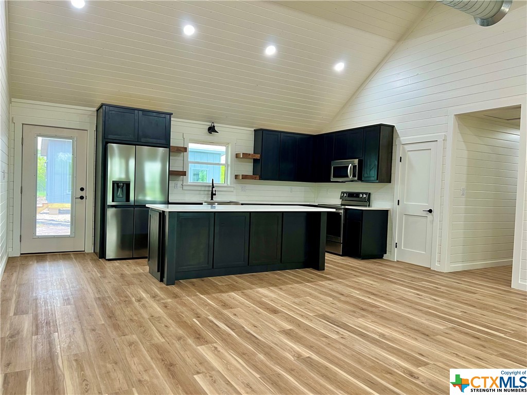 a kitchen with stainless steel appliances granite countertop a refrigerator and a sink