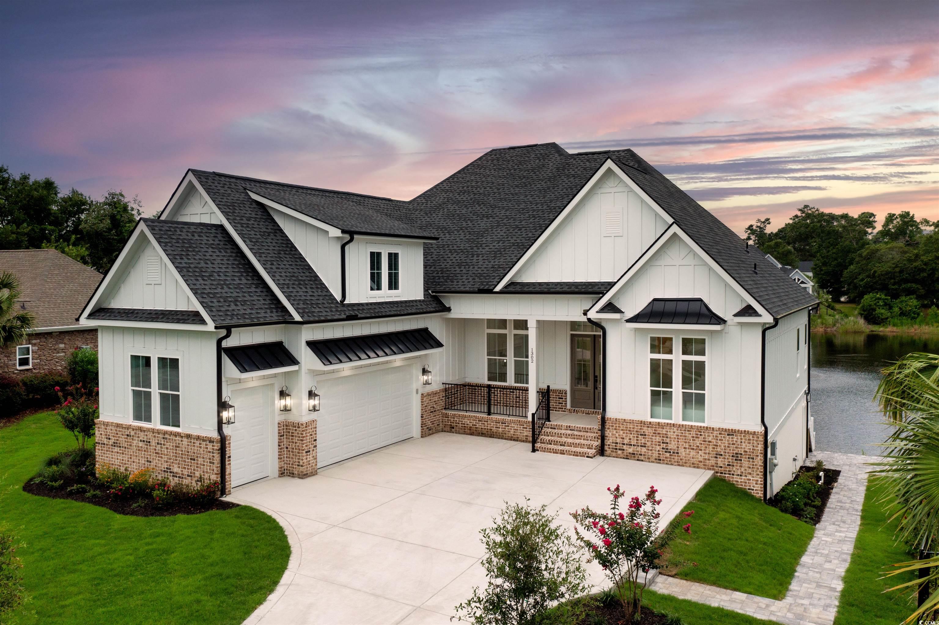 View of front of property with a garage and a yard