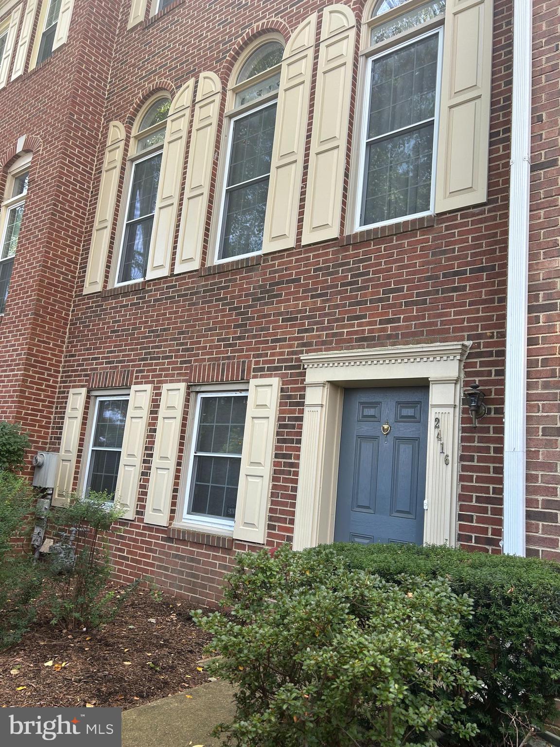 a view of a brick building next to a yard