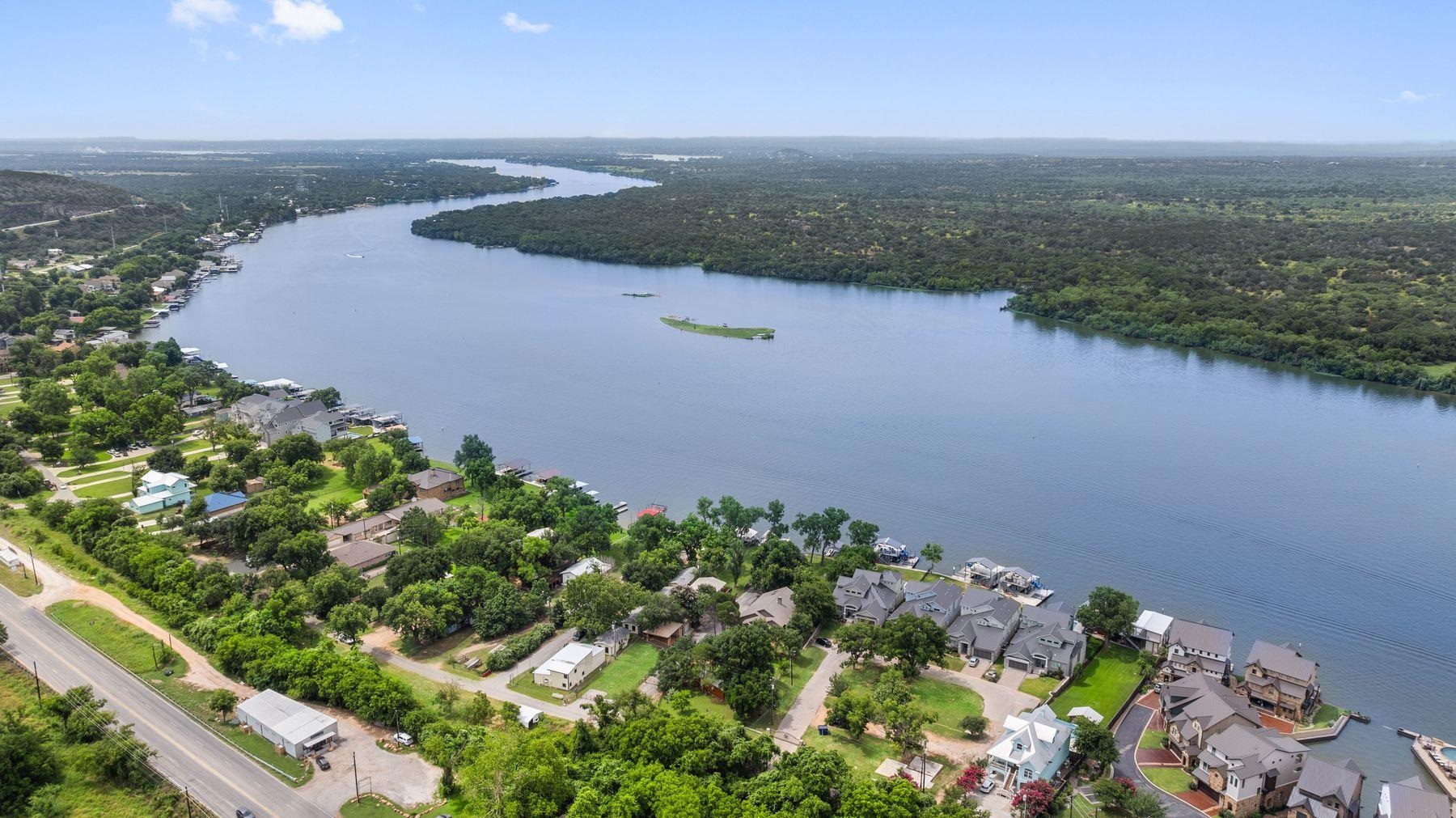 an aerial view of a house with a yard and lake view