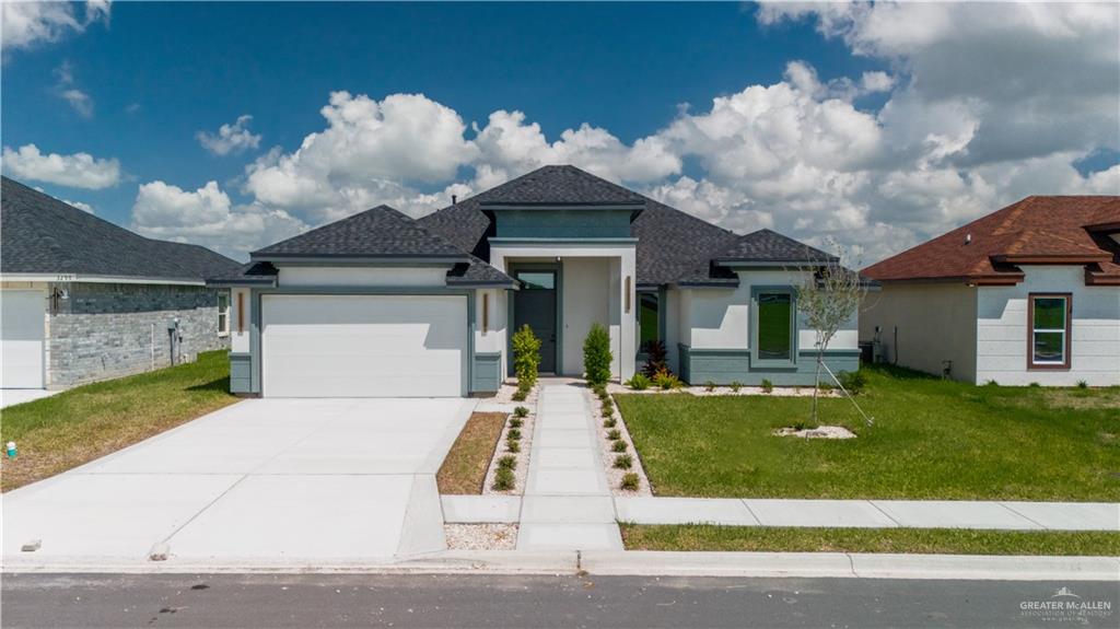 View of front of home with a front yard and a garage