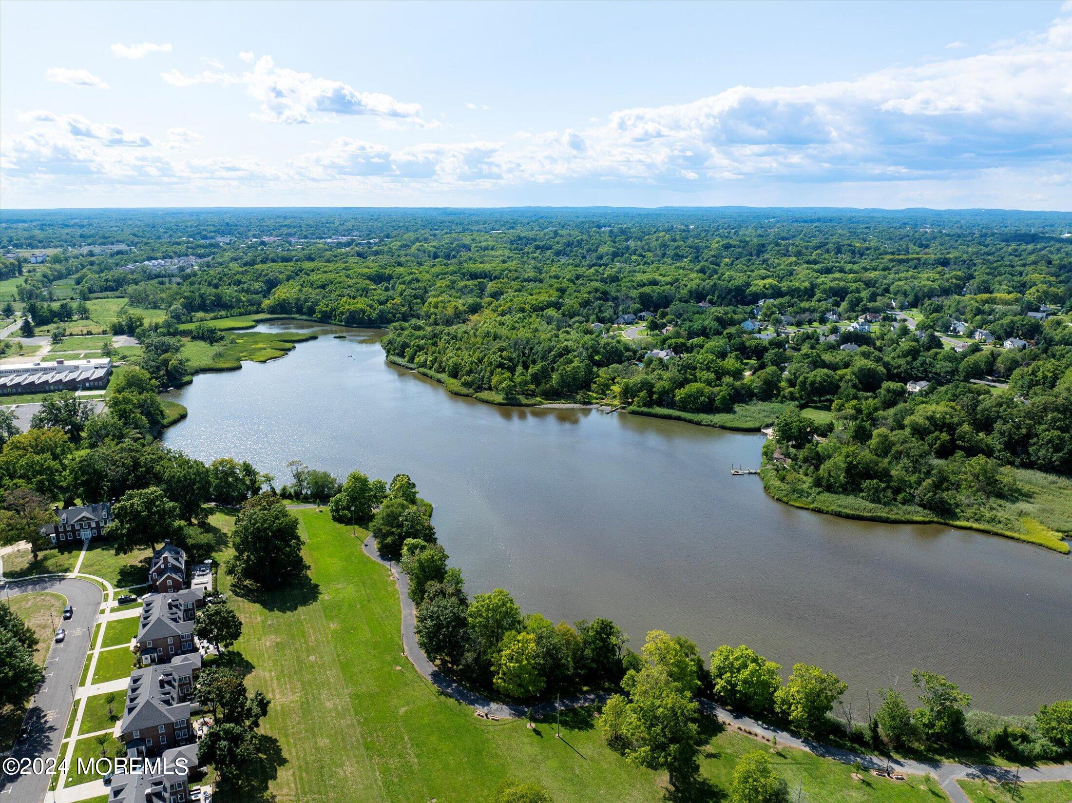 an aerial view of a house with a yard and lake view in back