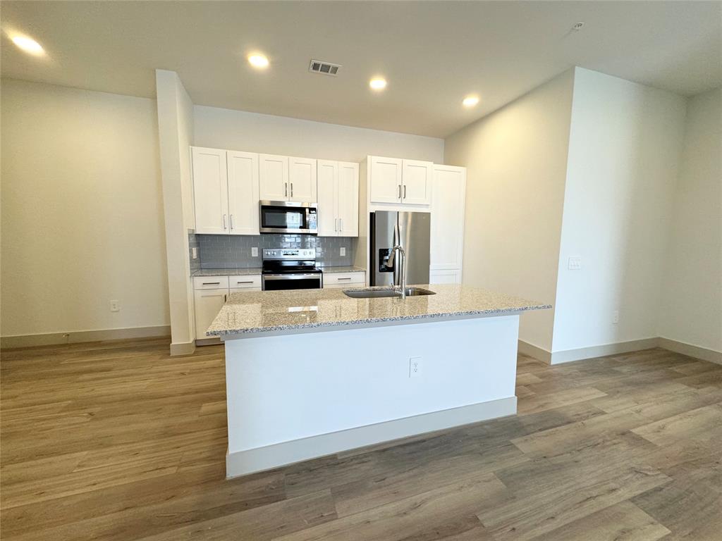 a kitchen with stainless steel appliances a refrigerator sink and microwave