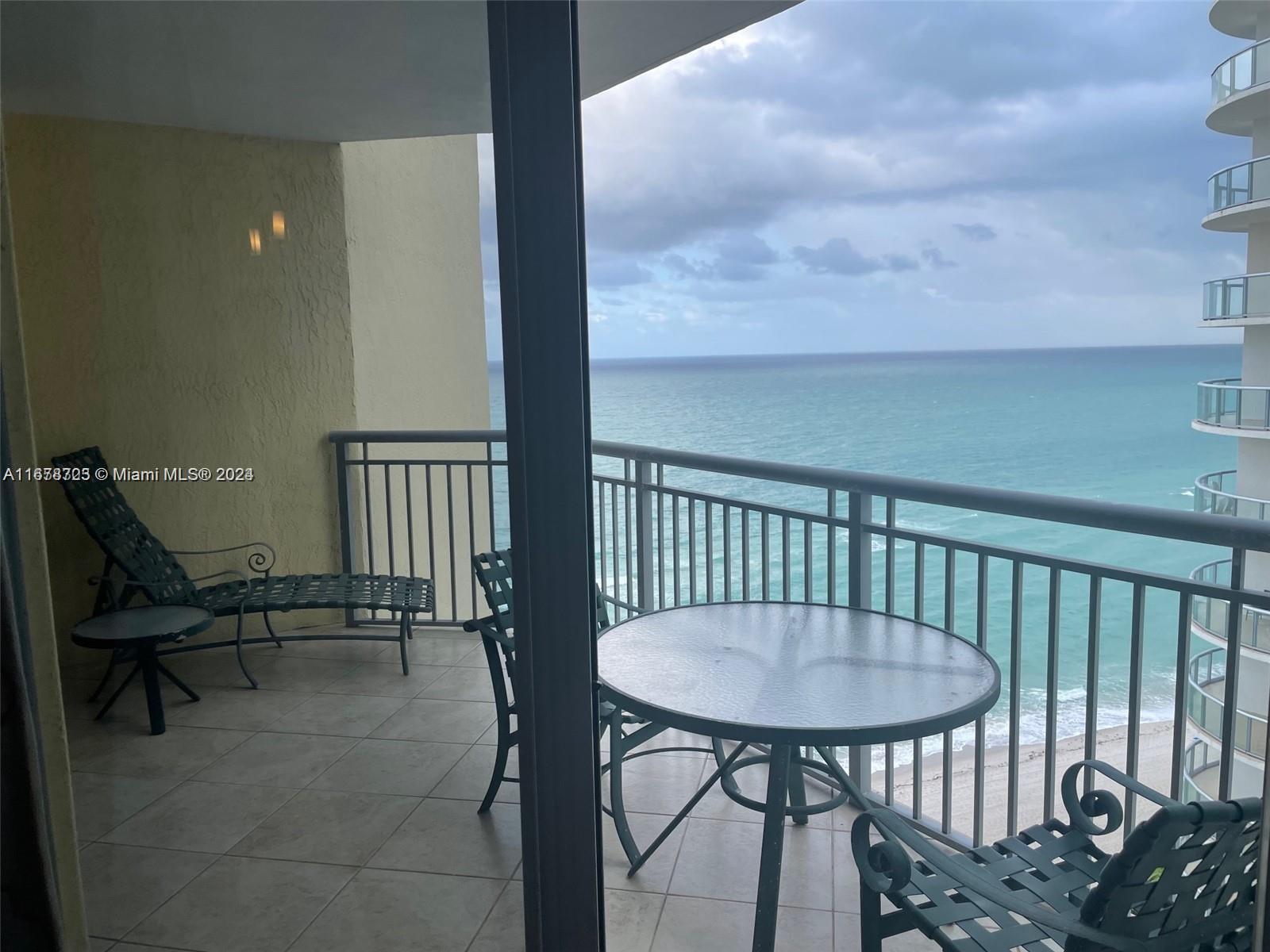 a balcony with a table and chairs