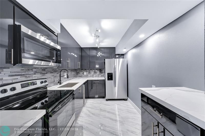 a kitchen with a sink stainless steel appliances and cabinets