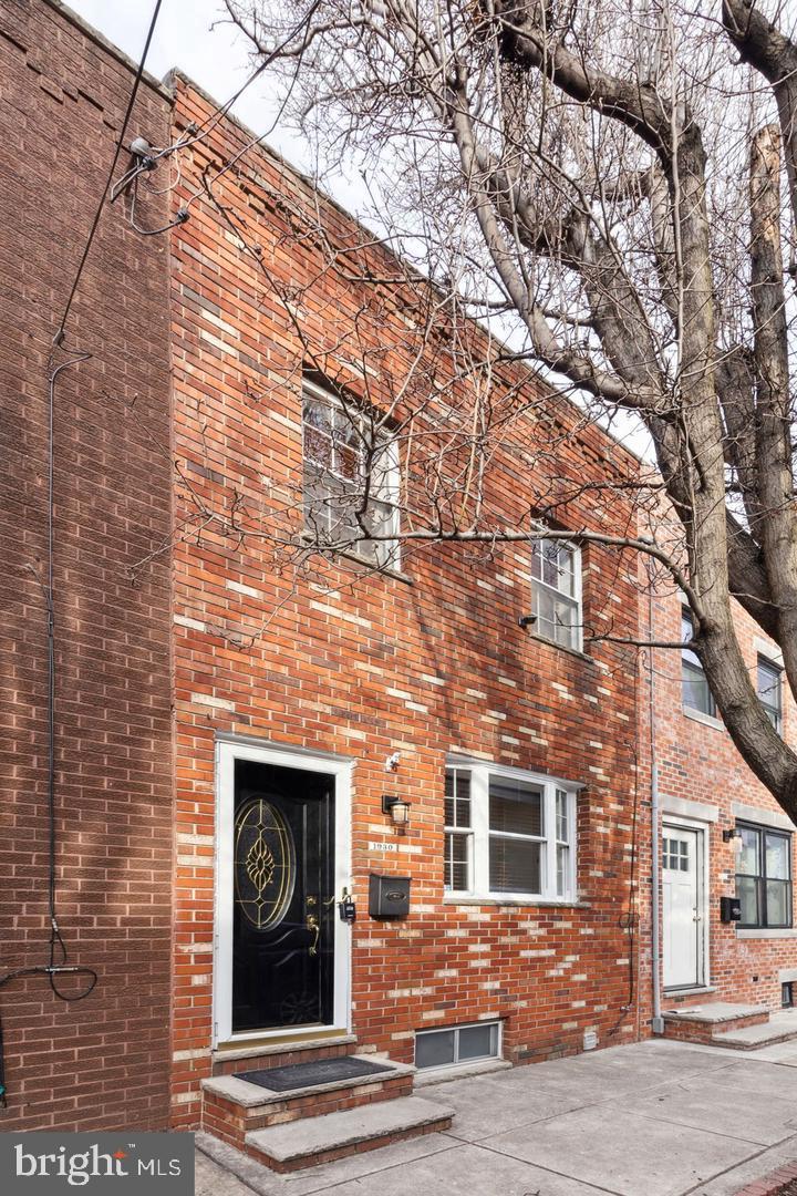 a front view of a building with a tree