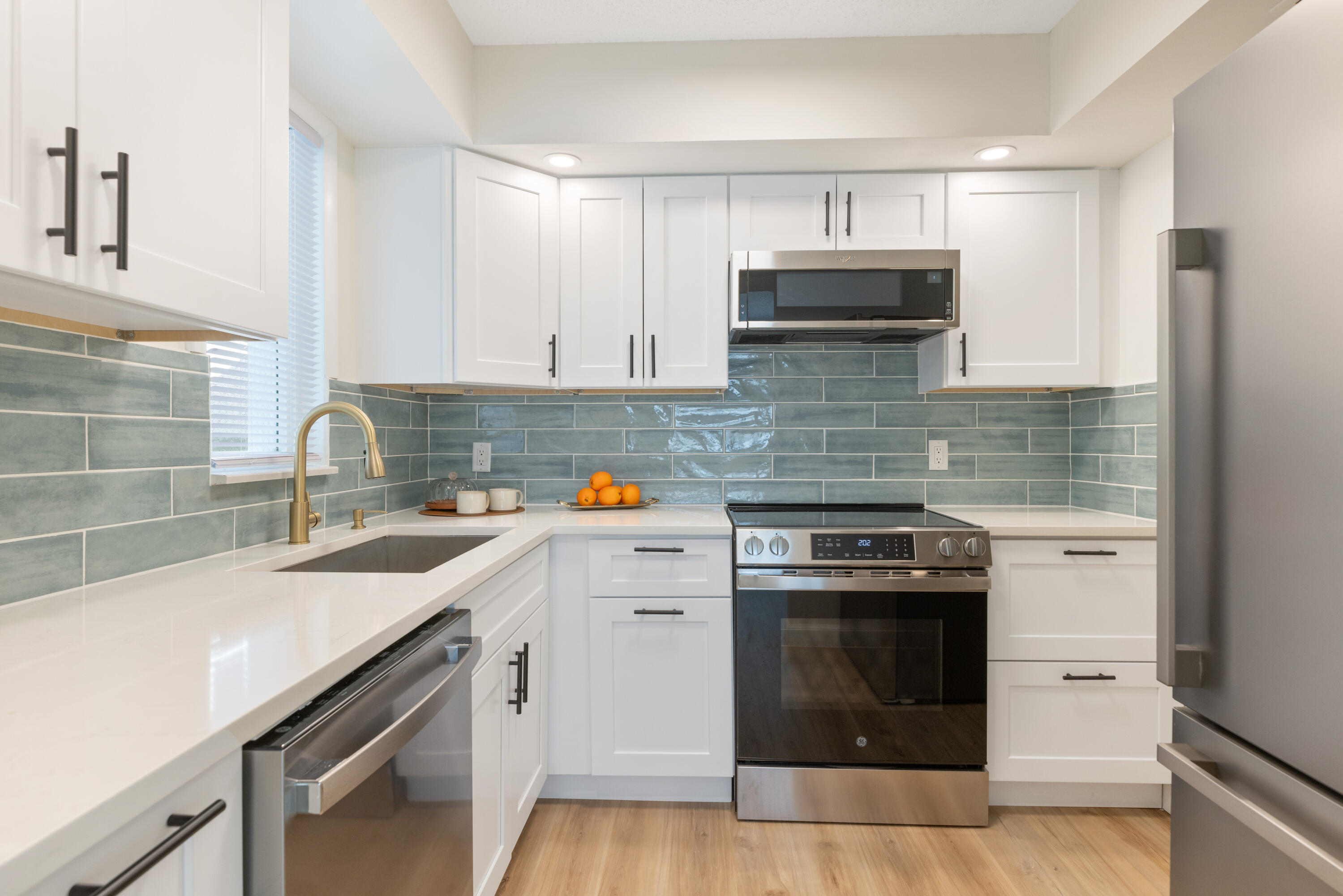 a kitchen with granite countertop a sink stainless steel appliances and cabinets