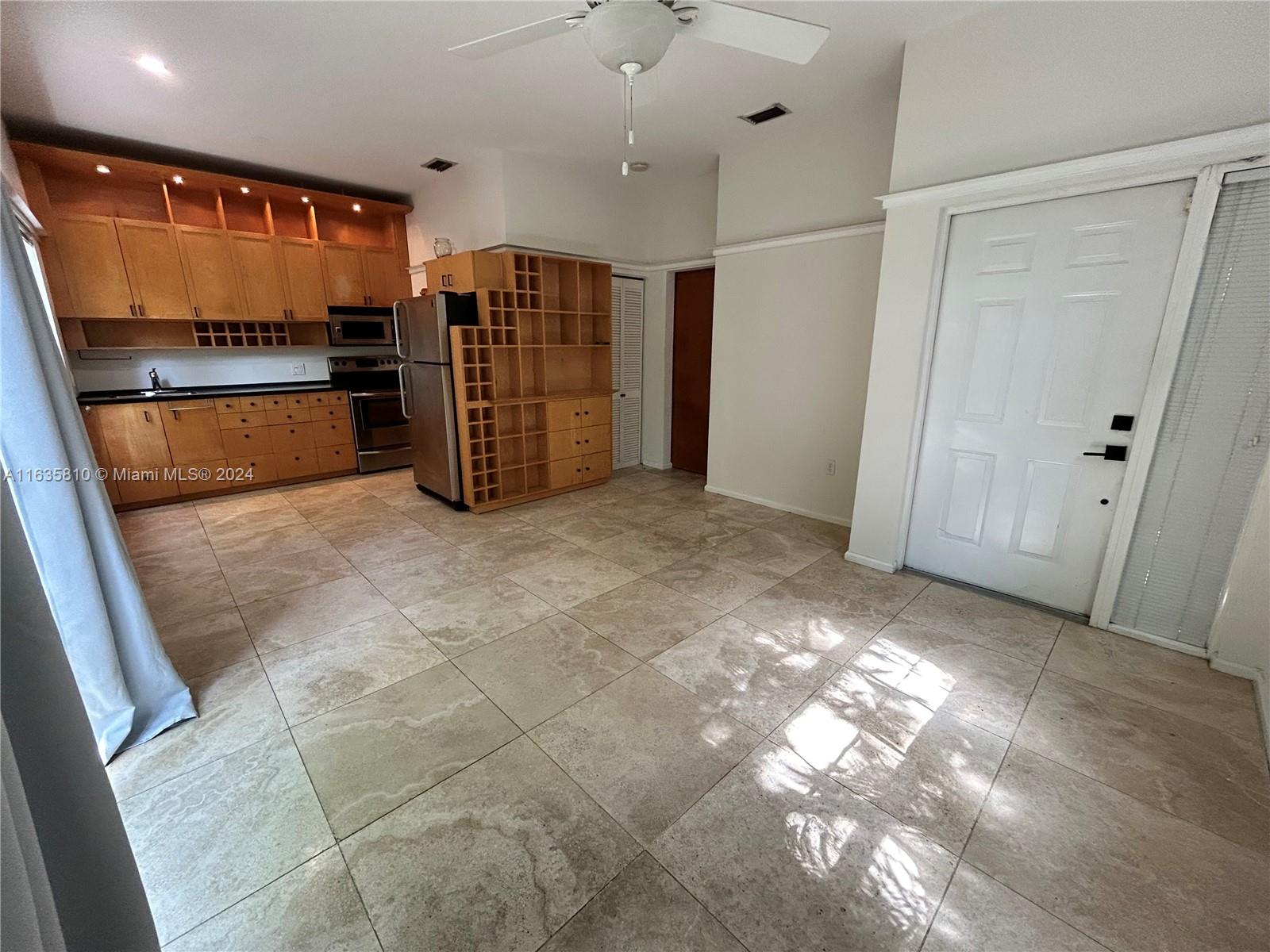 a view of kitchen with refrigerator and window