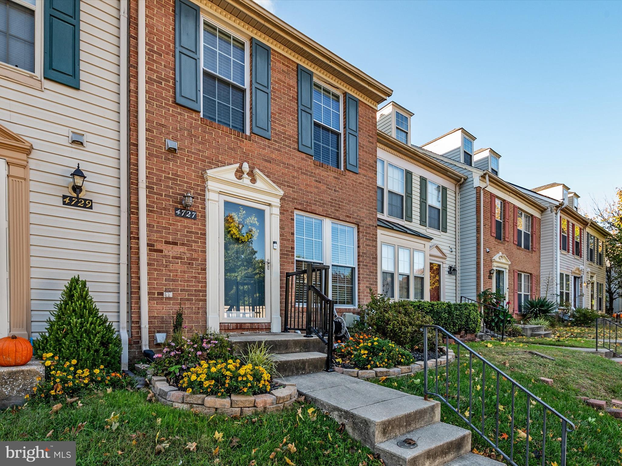 a front view of a multi story residential apartment building with yard and green space