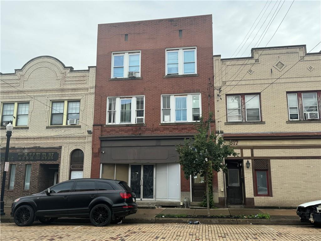 a view of a car parked in front of a brick house