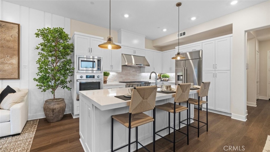 a kitchen with stainless steel appliances kitchen island a table and chairs