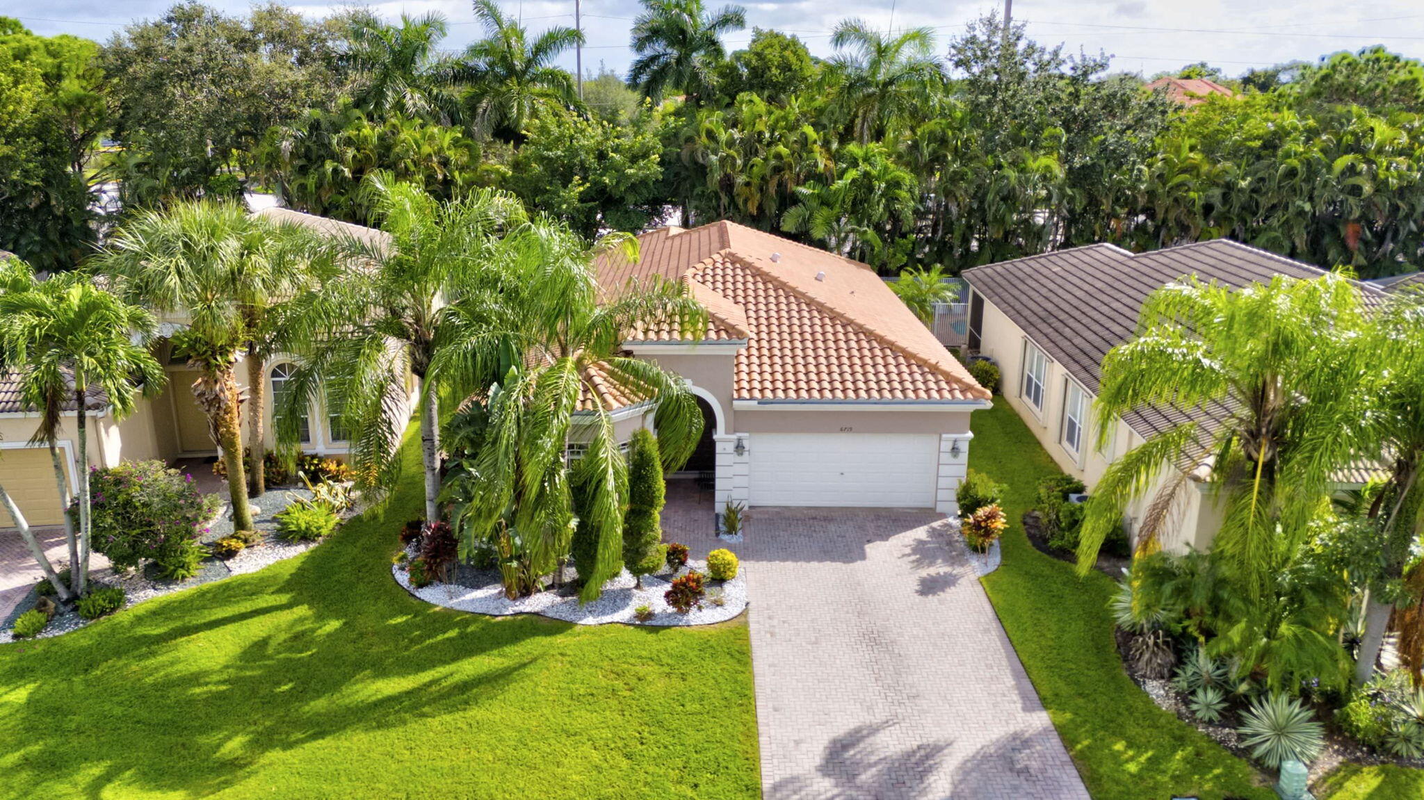 a view of house with a yard and potted plants