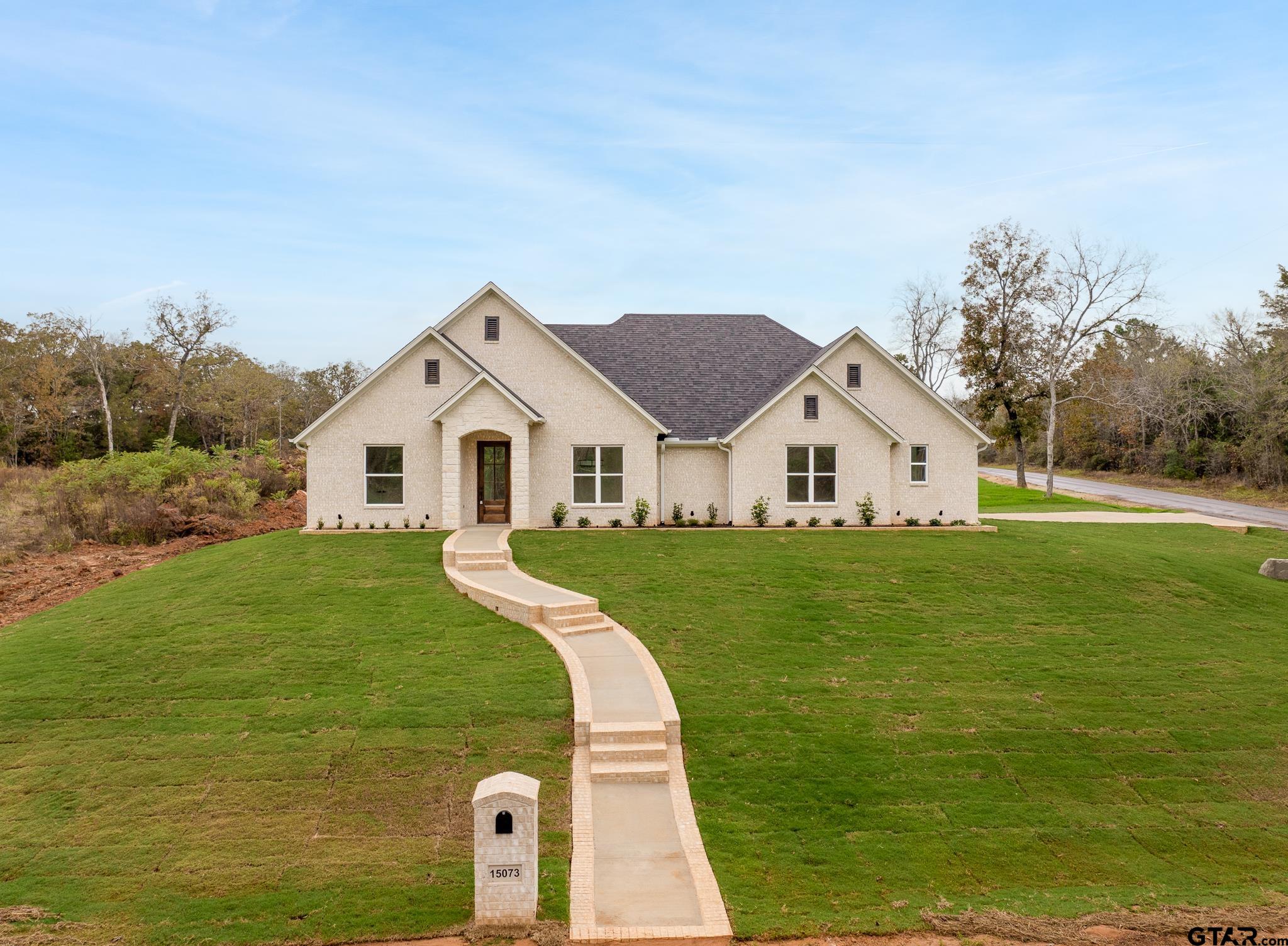 a view of a white house with a yard