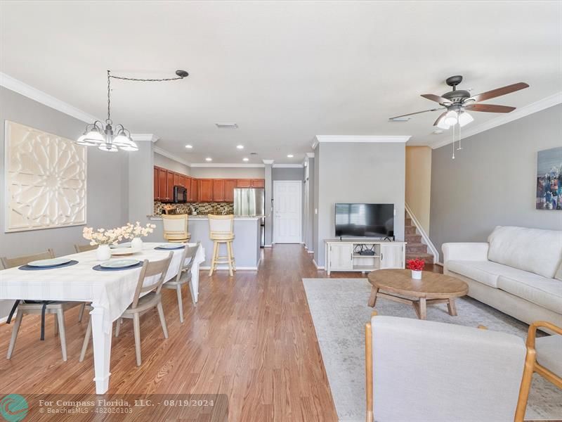 a living room with furniture kitchen view and a chandelier