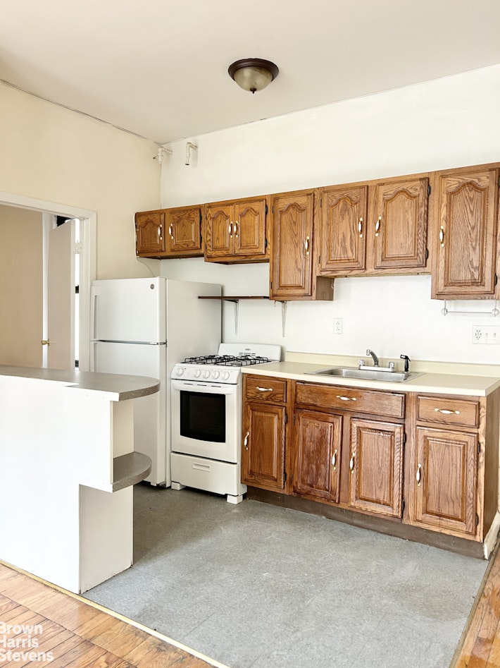 a kitchen with granite countertop a white stove and white cabinets