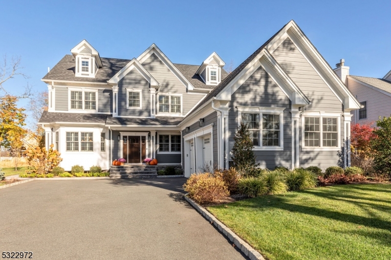 a view of a white house with a large windows and a yard