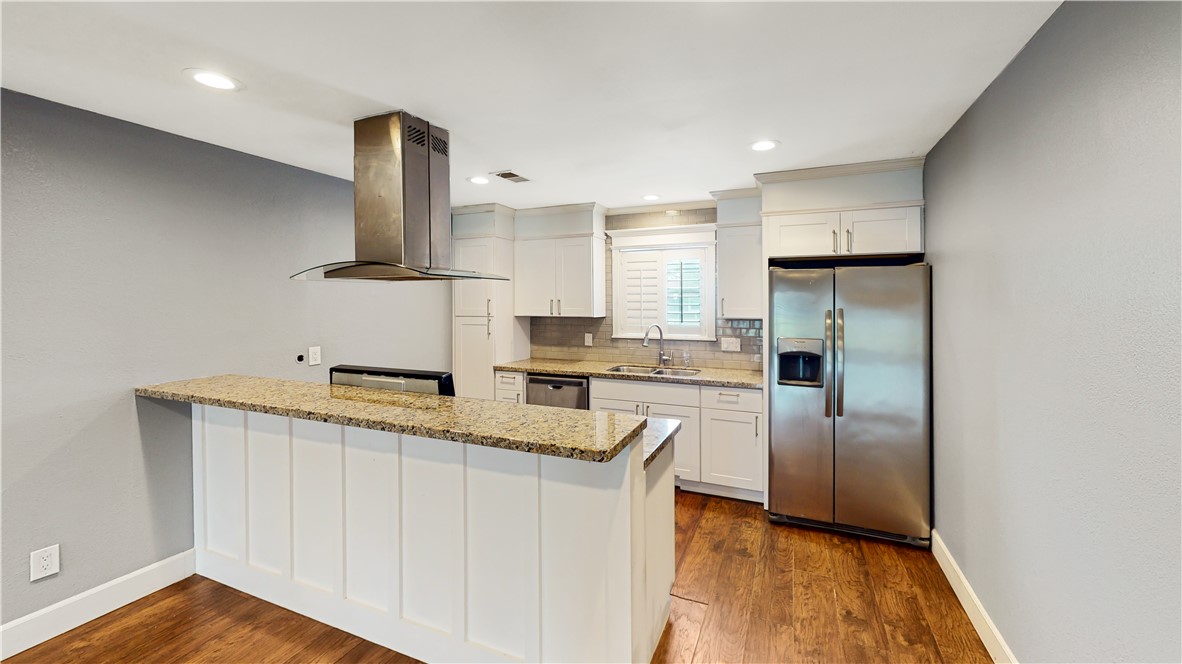 a kitchen with stainless steel appliances granite countertop a refrigerator a sink and a stove