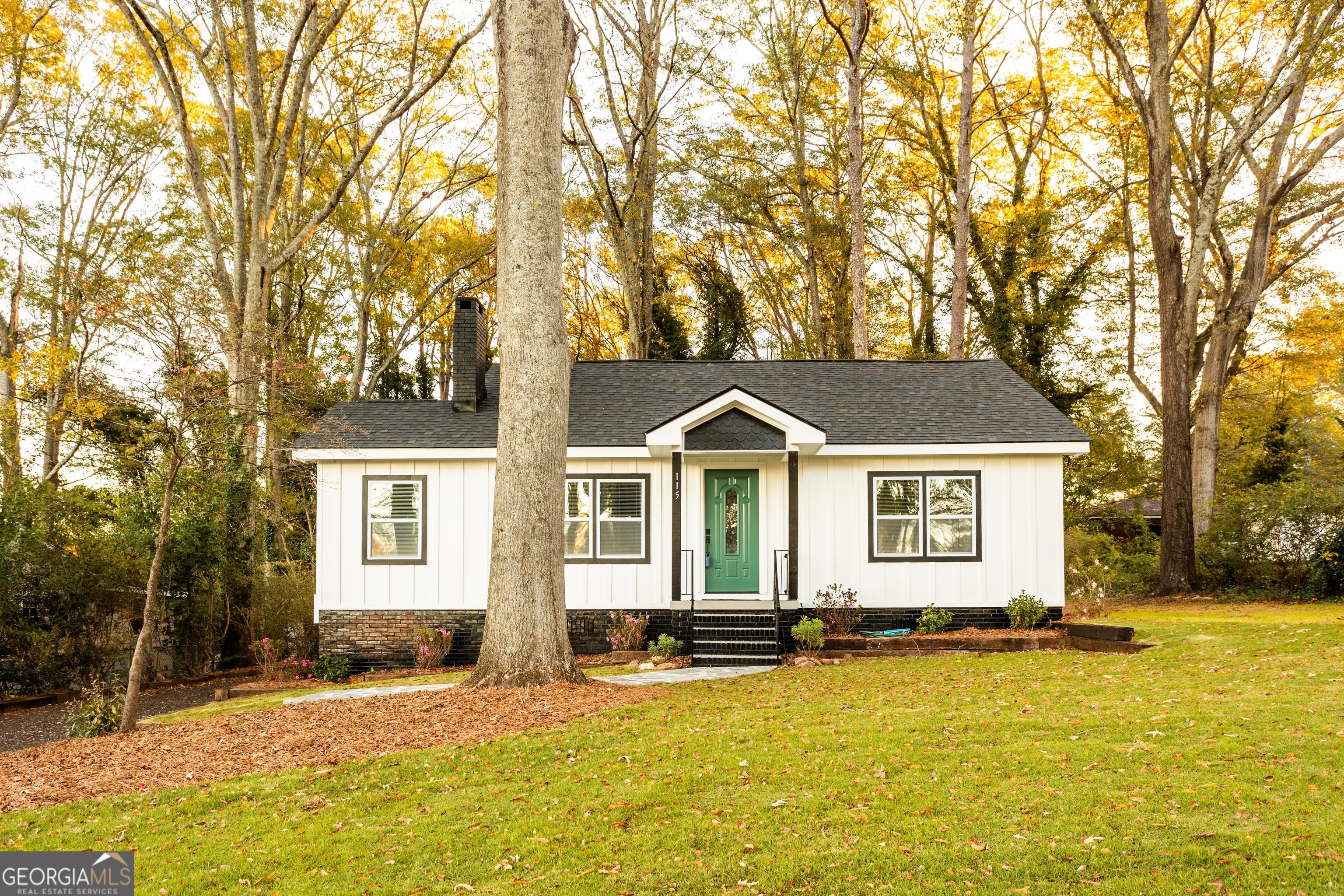 a front view of a house with yard and trees