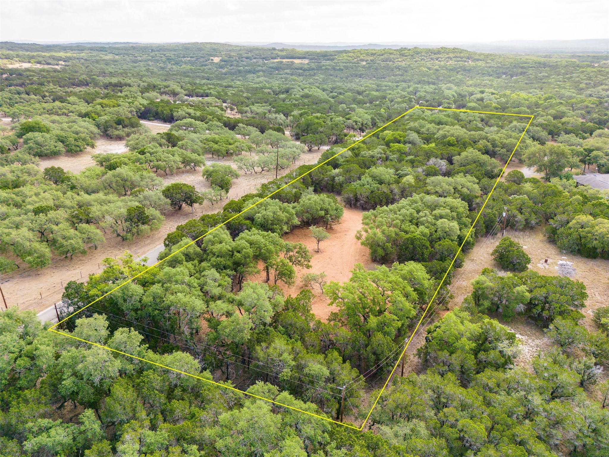 an aerial view of residential houses with outdoor space and trees