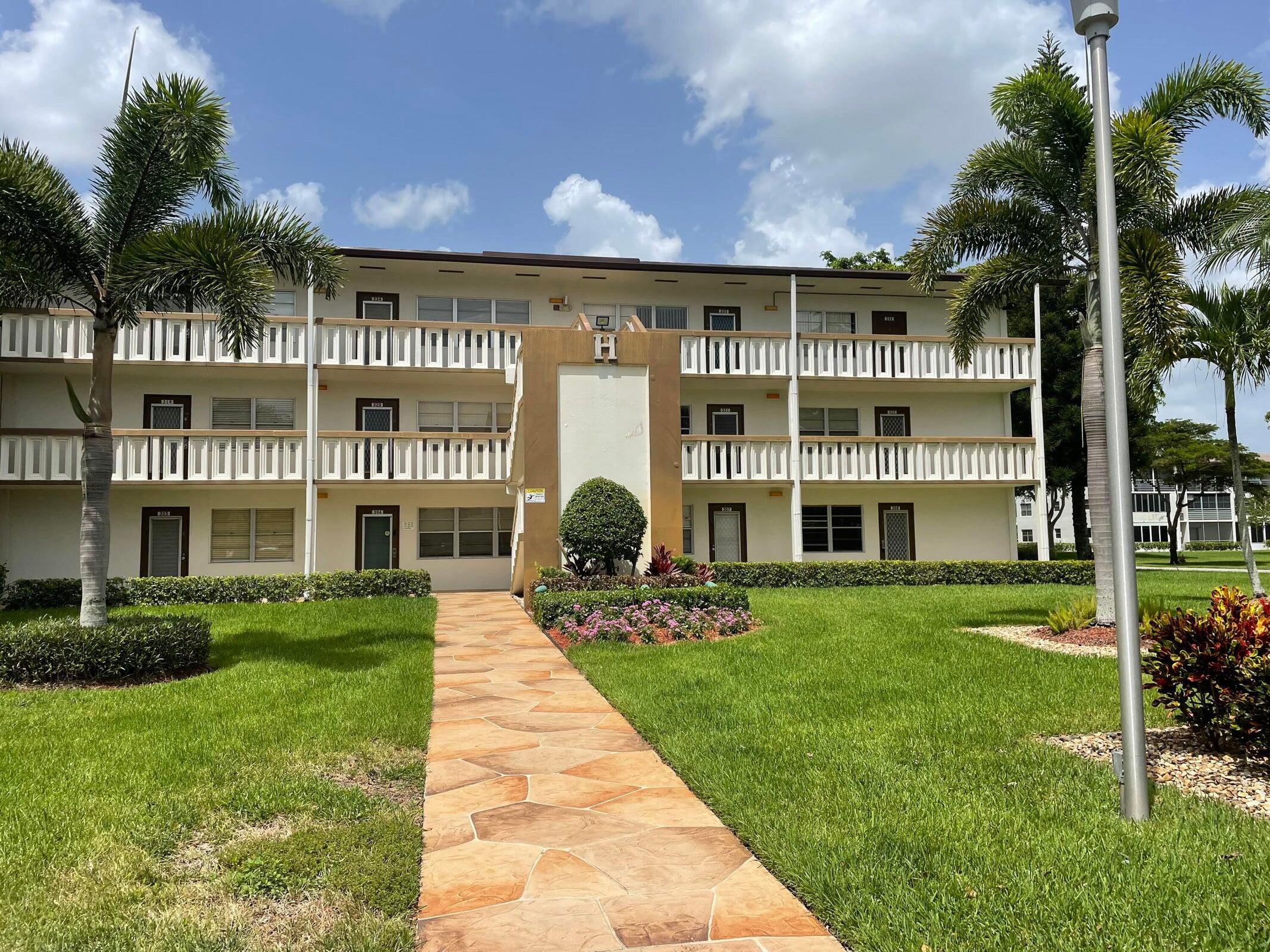 a front view of residential houses with yard and green space