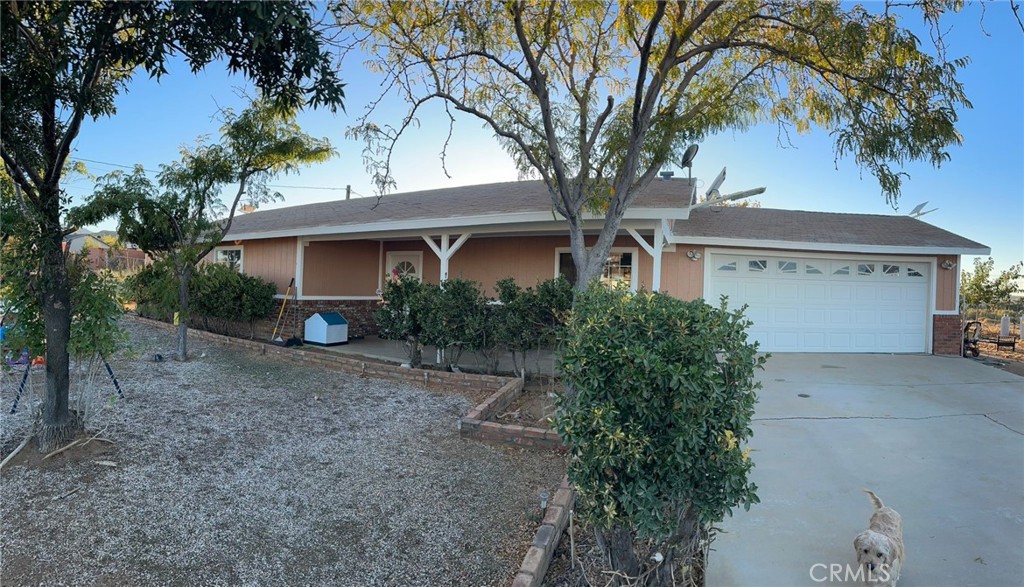 a front view of a house with a garden and trees