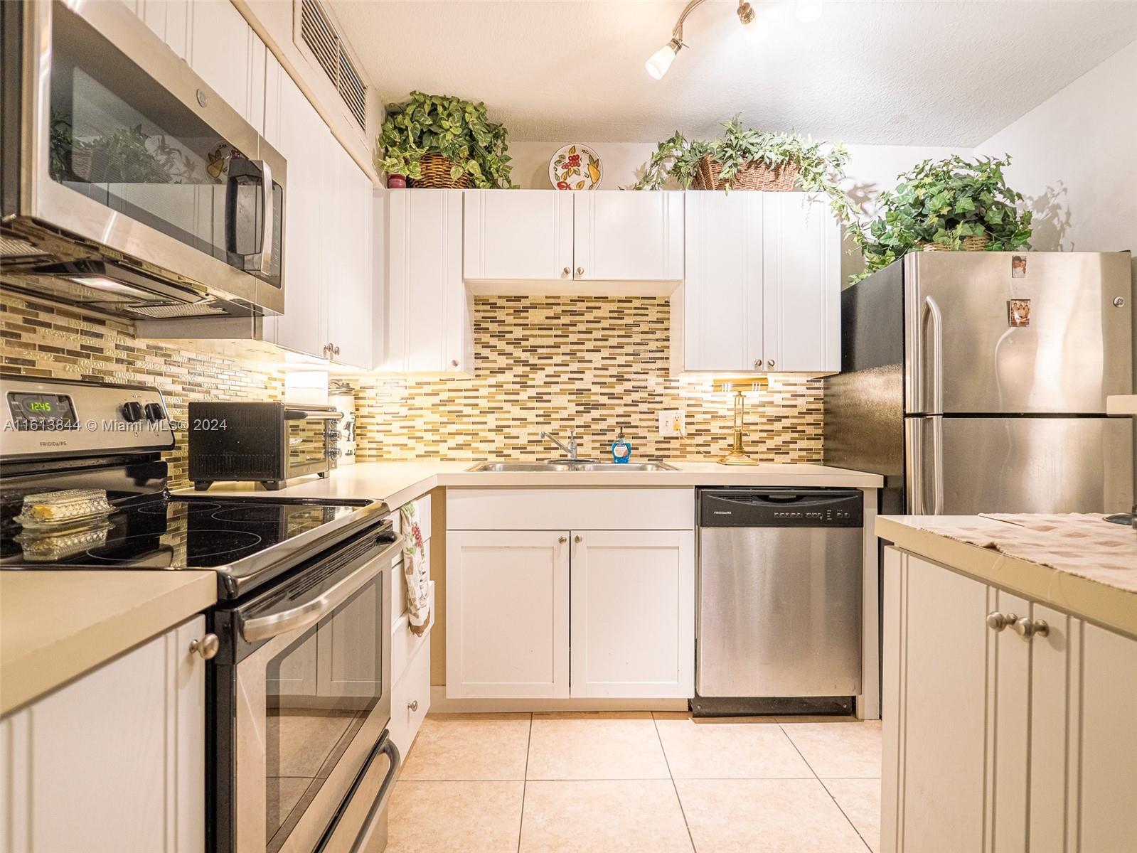 a kitchen with granite countertop a sink stove and refrigerator