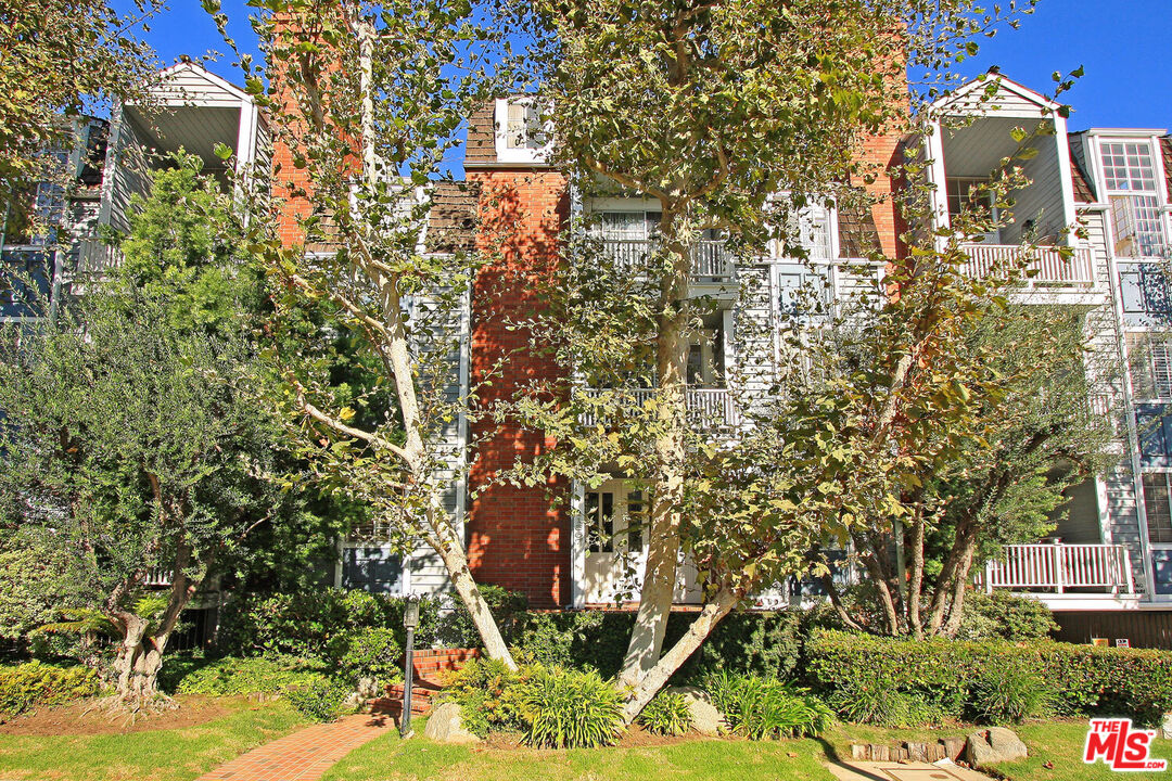 a view of a brick house with a tree