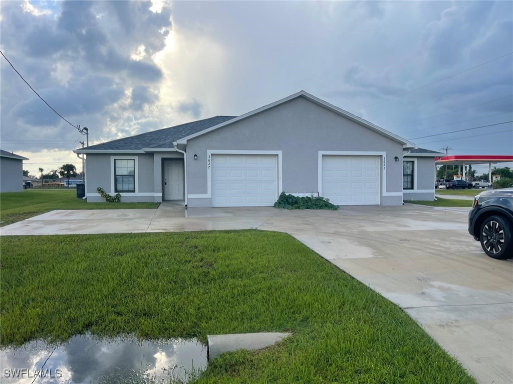 a view of a house with a yard and garage