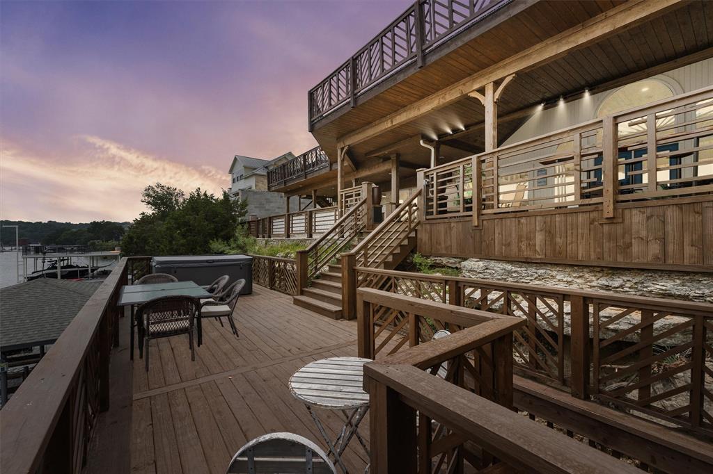 a view of a roof deck with table and chairs with wooden floor and fence