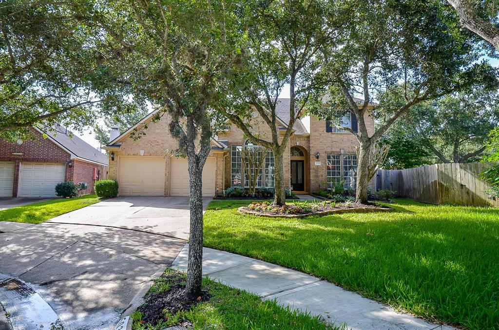 a front view of a house with a yard and an trees