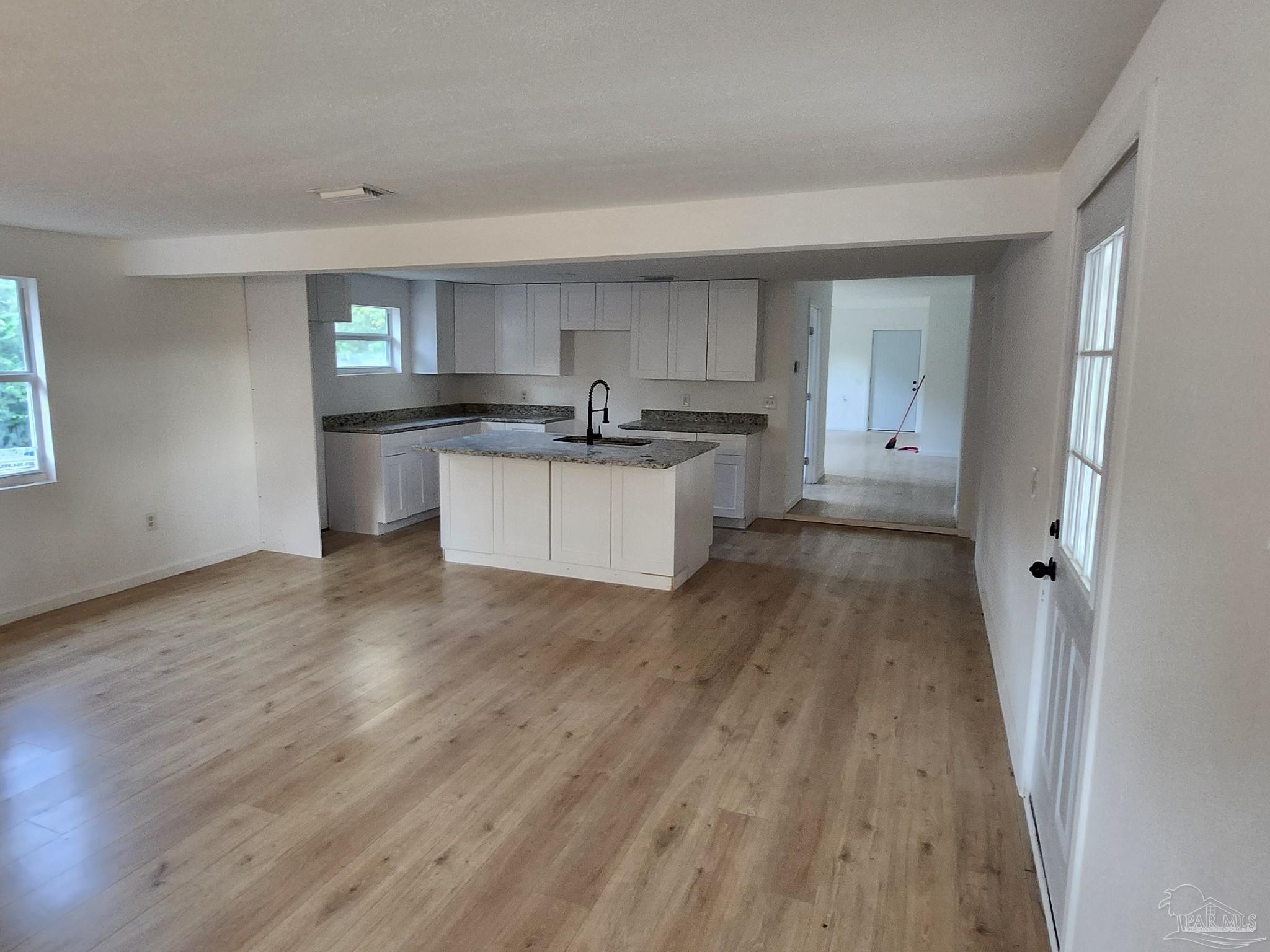 a kitchen with sink and wooden floor